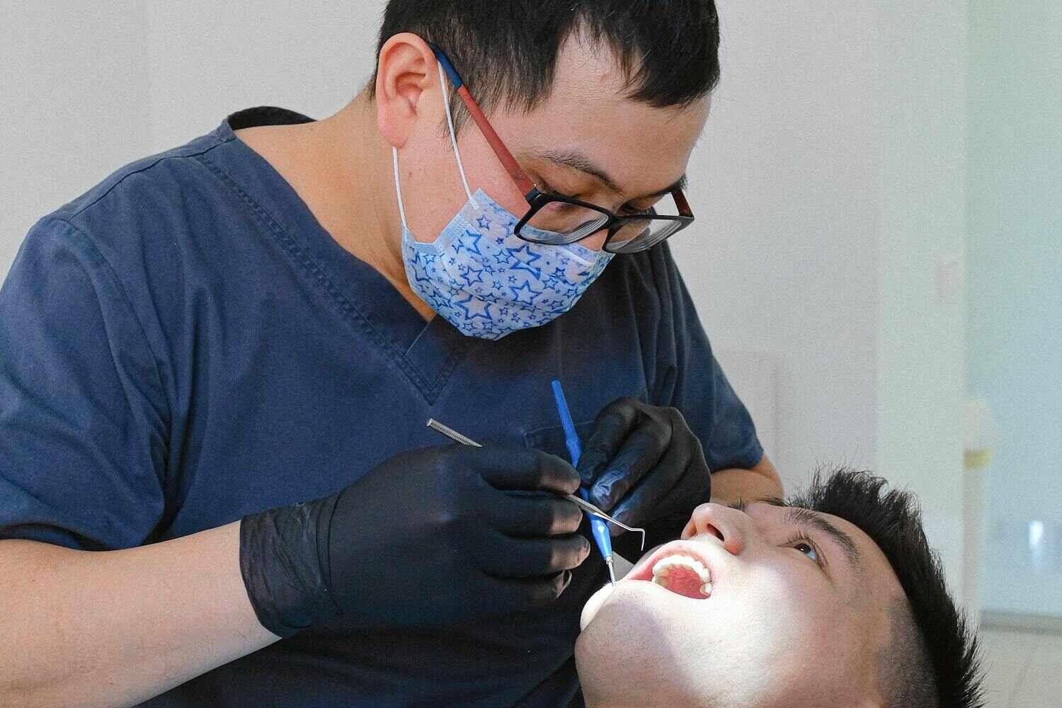 ISEIE研究中心 - 牙医为患者进行专业口腔检查展示临床研究实践 - ISEIE创新学院